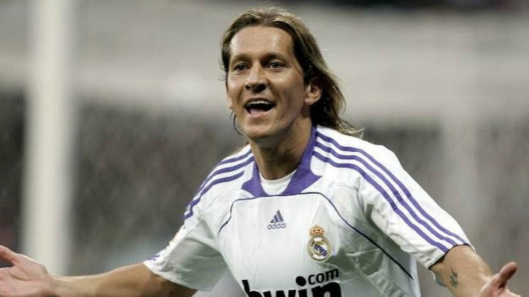 Soccer player in a Real Madrid jersey with Adidas and bwin logos, celebrating on the field.